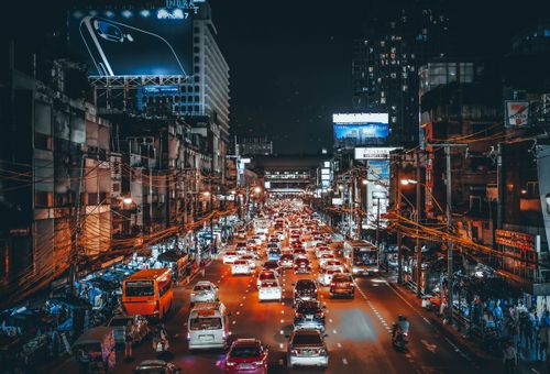 beleuchtette Straße mit Fahrzeugen bei Nacht